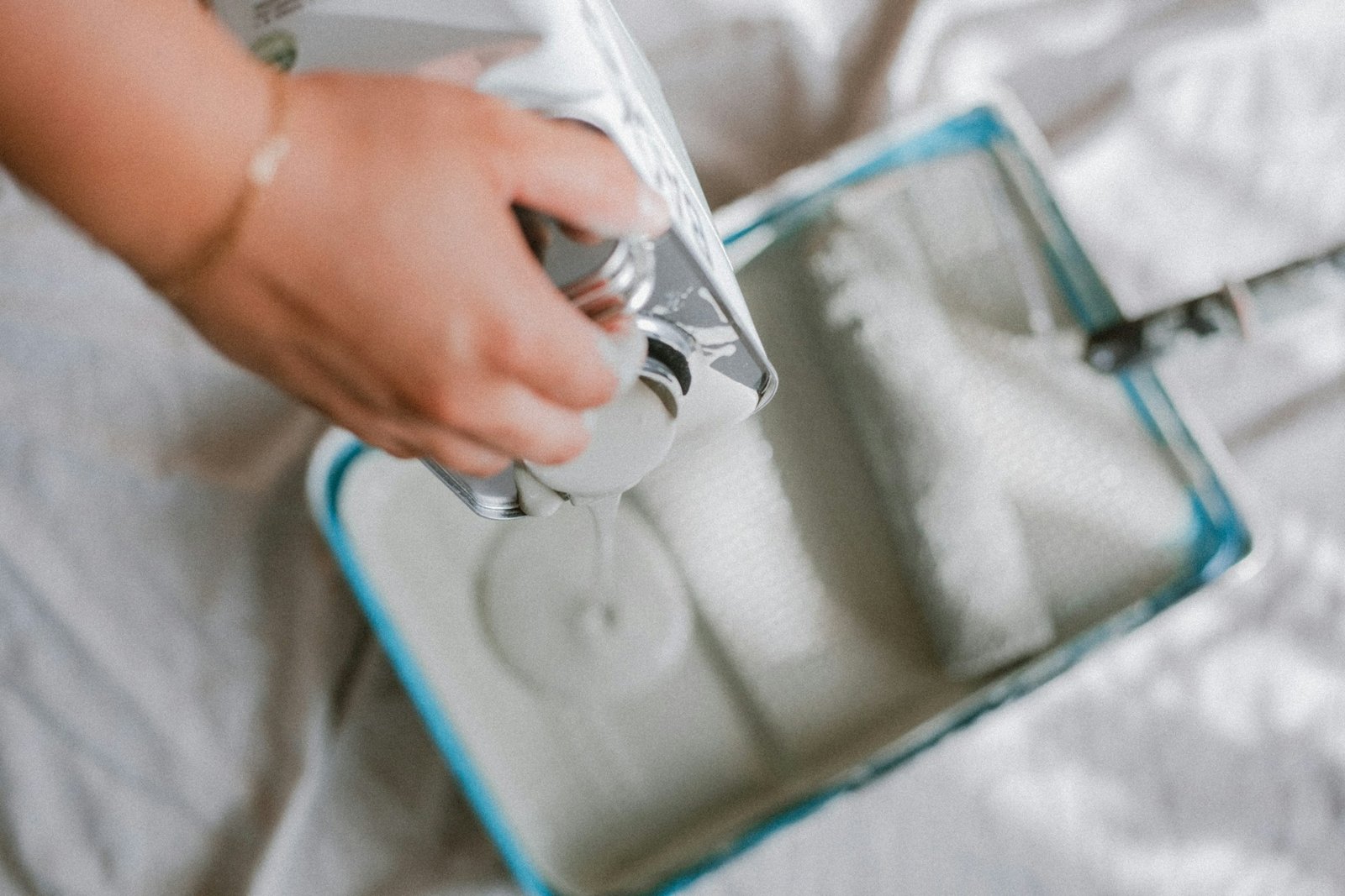 Farbroller trägt Farbe auf eine zuvor grundierte Wand auf