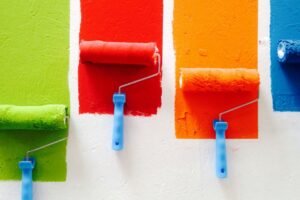 Farbroller wird gleichmäßig über eine helle Wand geführt