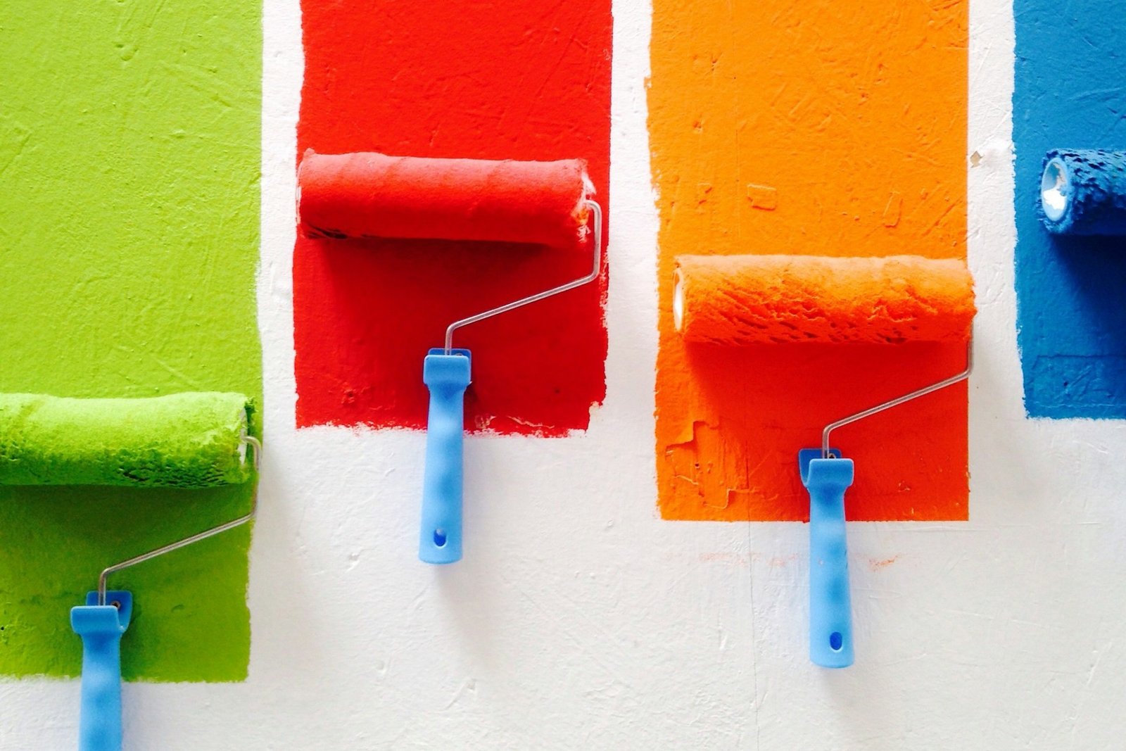 Farbroller wird gleichmäßig über eine helle Wand geführt