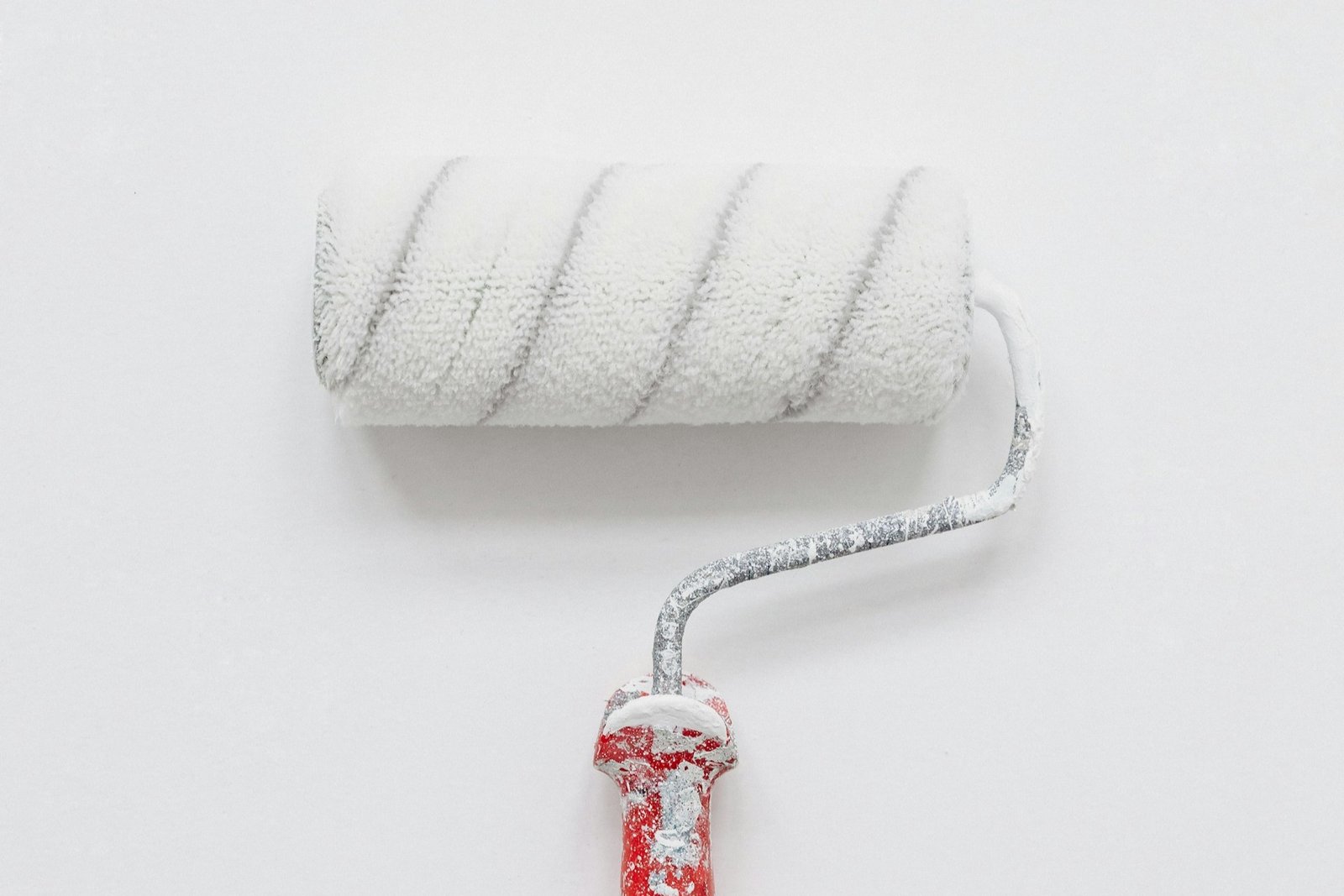 Farbroller verteilt Farbe auf einer Innenwand mit sichtbaren Streifen