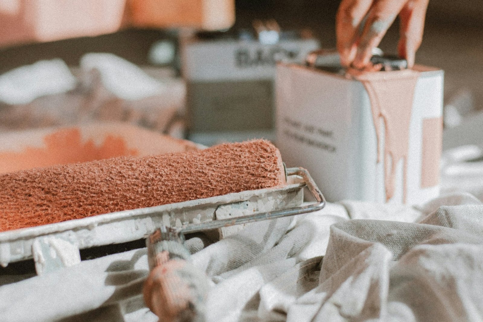 Farbroller trägt einen zweiten Anstrich auf eine Innenwand auf