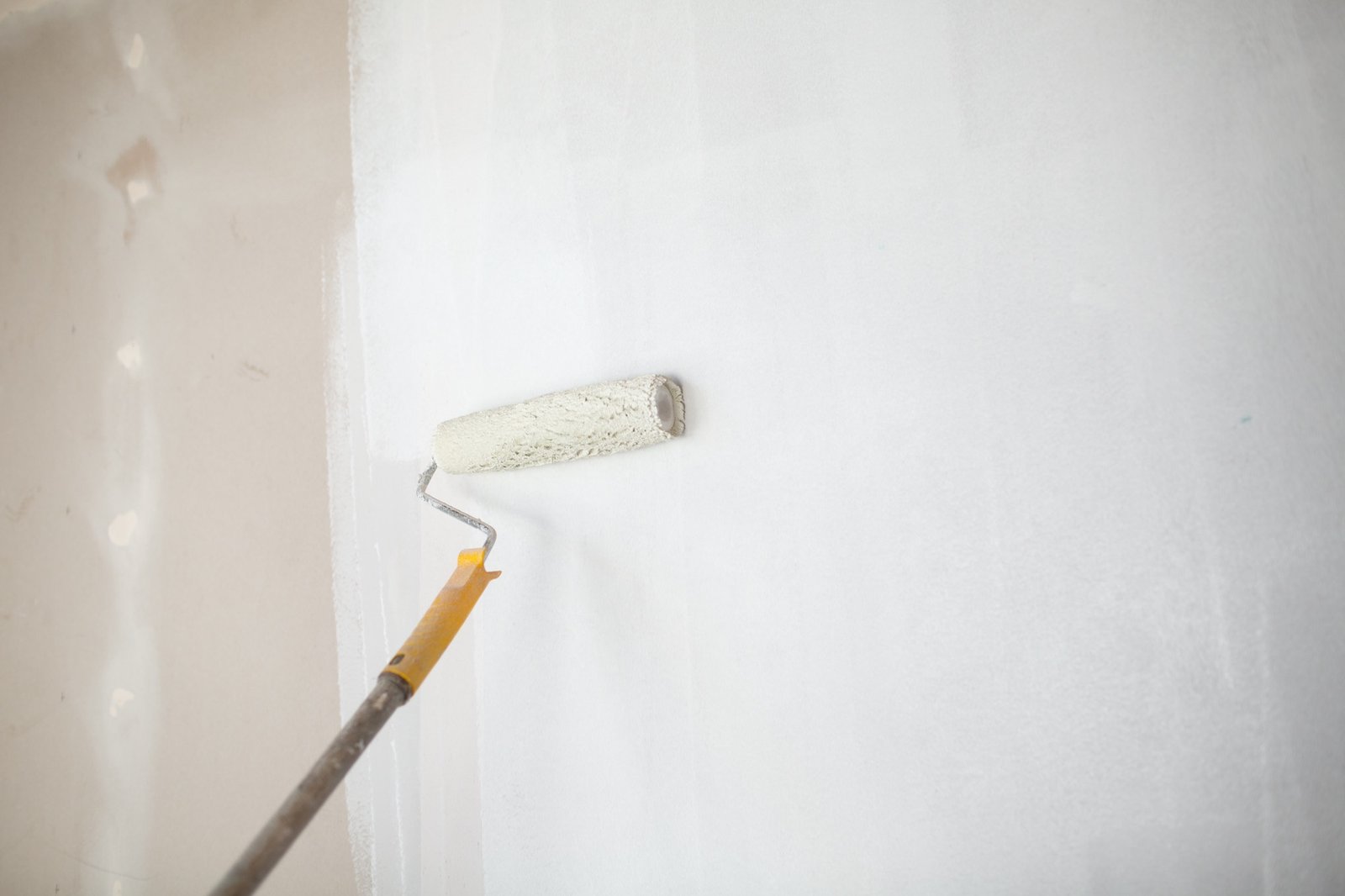 Weißer Anstrich an einer Wand mit ungleichmäßiger Deckung