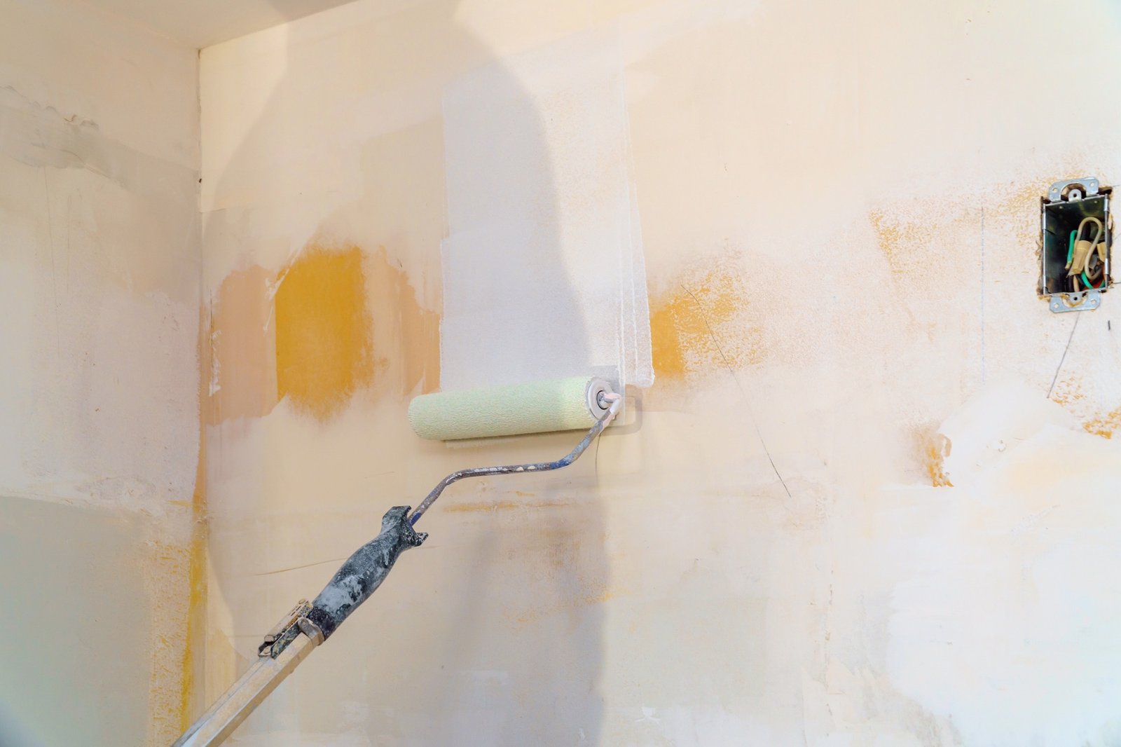 Farbroller an einer schlecht grundierten Wand